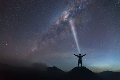 Silhouette man standing against star field at night