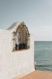 Lifeguard hut by sea against clear sky