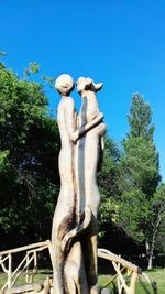 Low angle view of angel statue against clear blue sky