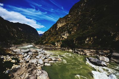 Scenic view of river amidst trees against sky