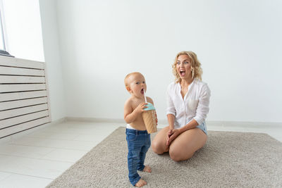 Full length of smiling woman sitting at home