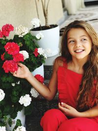 Teenage girl holding flowers while looking away
