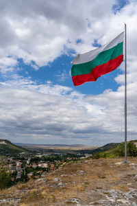 Scenic view of flag on landscape against sky