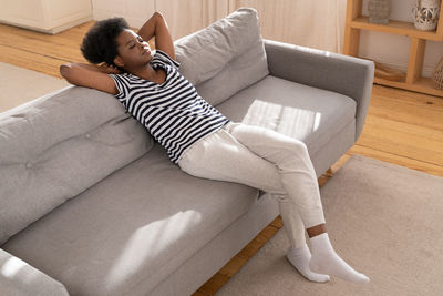 High angle view of woman lying on sofa at home