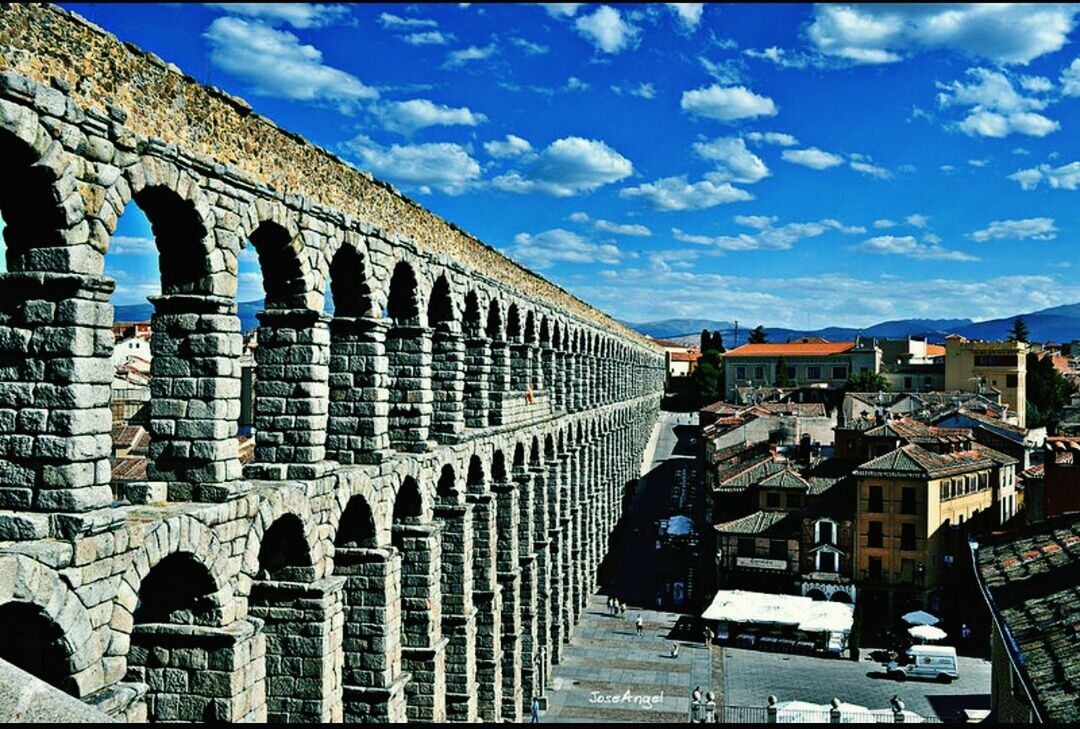 architecture, built structure, building exterior, sky, history, arch, old, travel destinations, the past, cloud - sky, blue, sunlight, famous place, city, ancient, building, cloud, tourism, day, stone wall