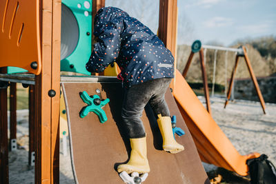 Rear view of girl playing at playground