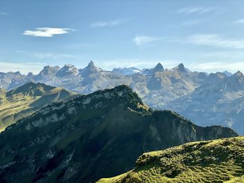 Scenic view over swiss mountaintops against blue skies