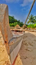 Close-up of wood on sand against sky
