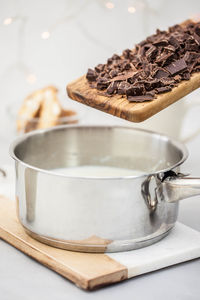 Close-up of wok with chocolate on cutting board