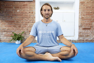 Young man meditating while sitting on floor. self confident