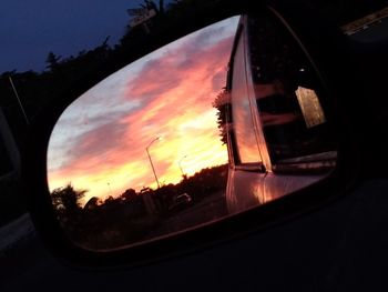 Reflection of orange sky on side-view mirror