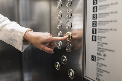 Hand of businesswoman pressing elevator button