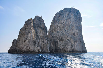 Rock formations in sea against sky