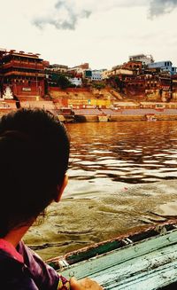 Portrait of woman by river in city against sky