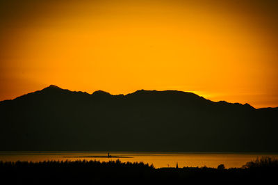 Scenic view of silhouette mountains against orange sky