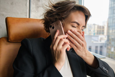 Thoughtful young woman using mobile phone