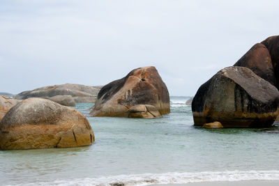 Rocks on sea shore against sky