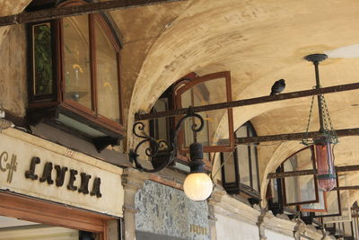 Low angle view of lamp hanging on ceiling of old building