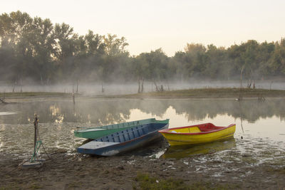 Boats moored in lake against sky