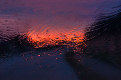 Full frame shot of wet glass during sunset