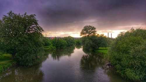 Scenic view of river against cloudy sky