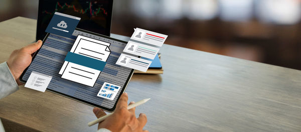 Cropped hands of woman using laptop on table