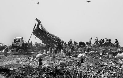 People working on field against clear sky