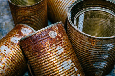 Close-up of rusty metallic containers on street