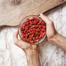 High angle view of hand holding strawberries