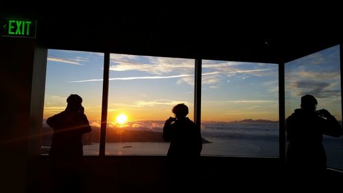 Silhouette of people in sea at sunset