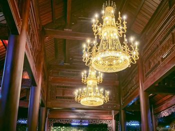 Low angle view of illuminated chandelier hanging in building