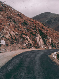 Road amidst mountains against sky