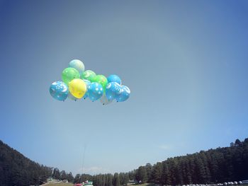 Low angle view of balloons against blue sky