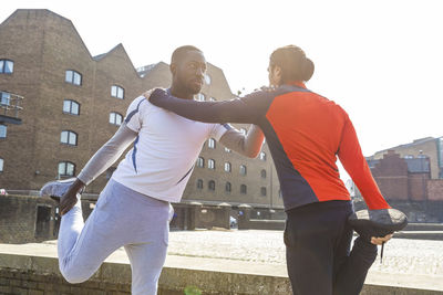 Rear view of couple against buildings in city