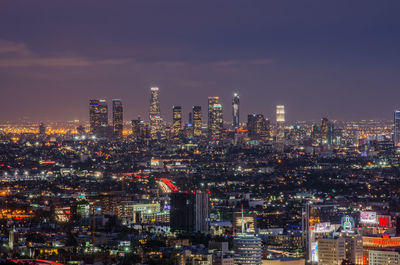 Illuminated cityscape against sky at night