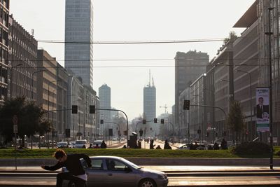 Cars on road in city against sky