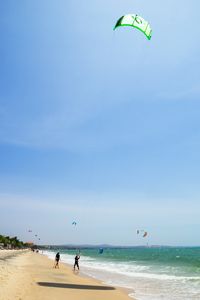 People at beach against sky