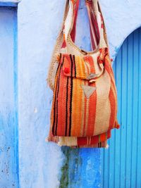 Close-up of shoulder bag hanging outside blue house