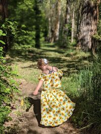 Rear view of young girl standing in forest