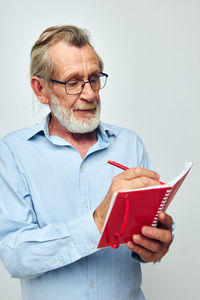 Portrait of man holding book against white background