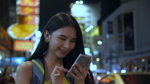 Young woman using mobile phone at night