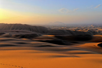 Scenic view of desert against sky during sunset