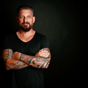 Portrait of man standing against black background