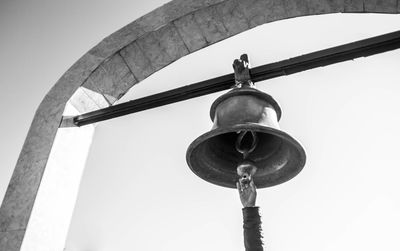 Hands reaching for the bell hanging in hindu temple