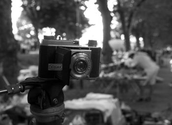 Close-up of coin-operated binoculars against trees