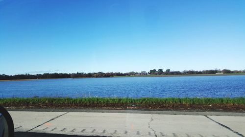 Scenic view of lake against clear blue sky