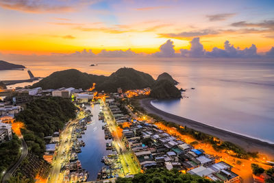 High angle view of road by buildings against sky during sunset