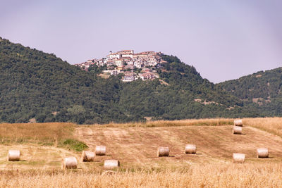 Hay bales on field against sky