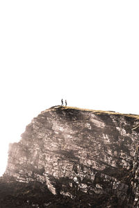 Man on cliff against clear sky