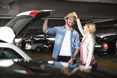 Woman standing with umbrella in car